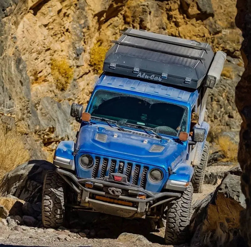 Blue 4x4 Jeep Overlanding Down a Boulder Trail